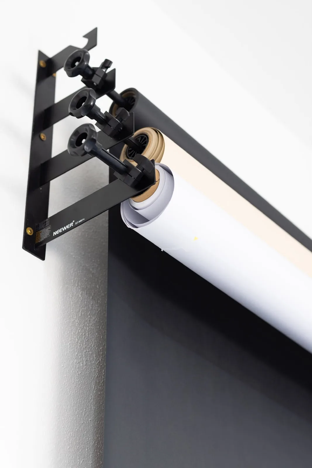 Black, white and beige paper backdrops on wall-mounted rollers