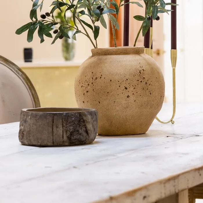 Clay vase with olive branches on a white-washed wooden table